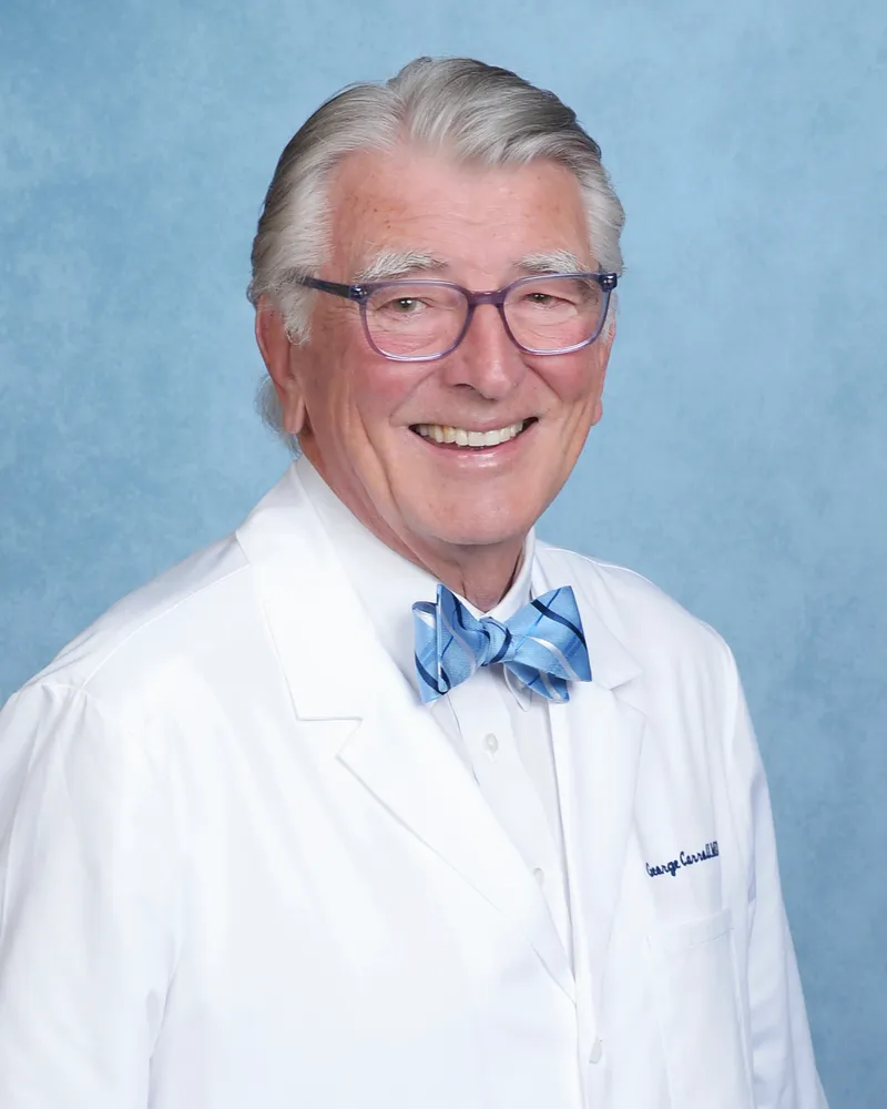 George W. Carroll, MD, in a white medical coat