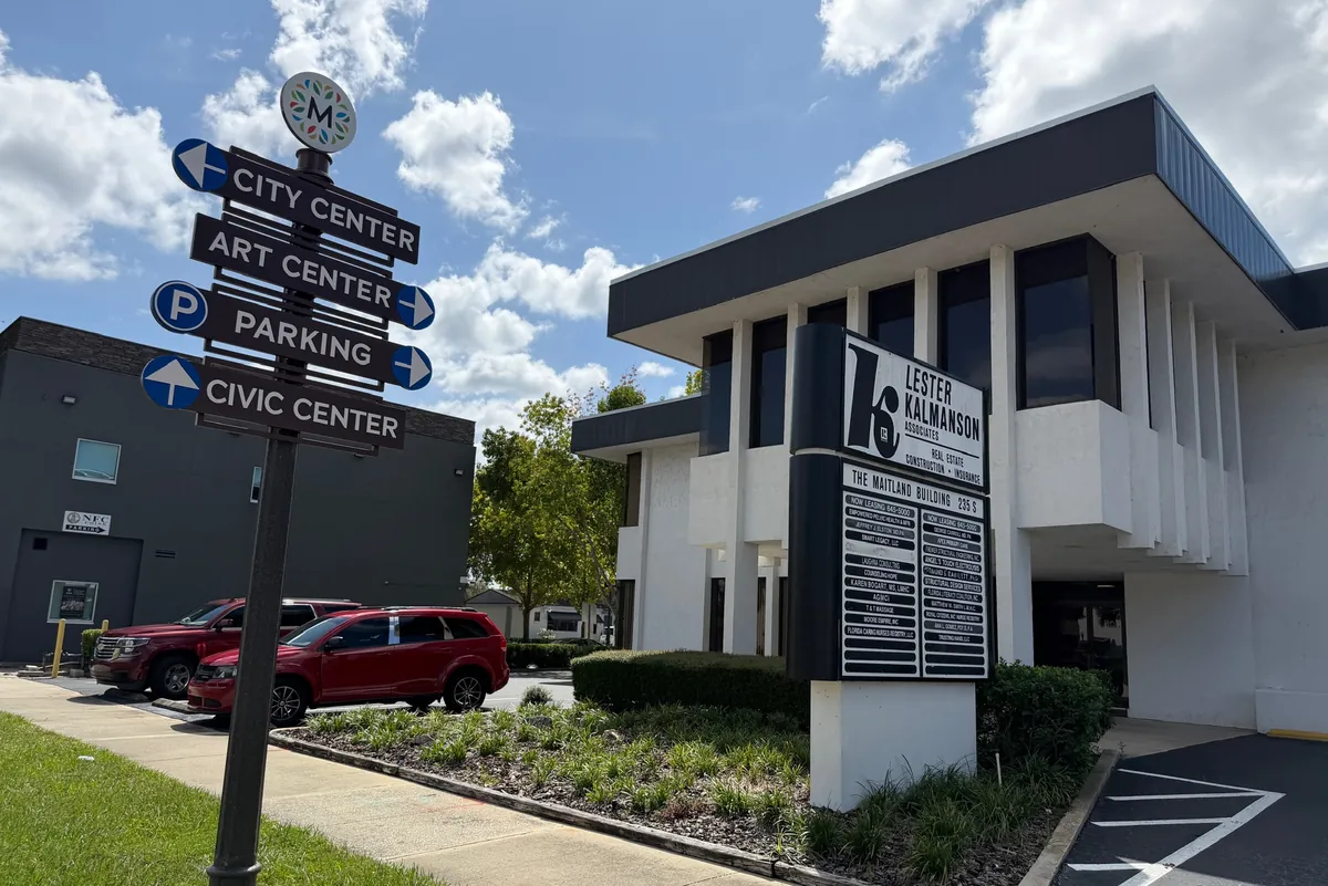 The Maitland Building on Maitland Avenue, with a Maitland wayfinding sign pointing to City Center, Art Center, parking and Civic Center
