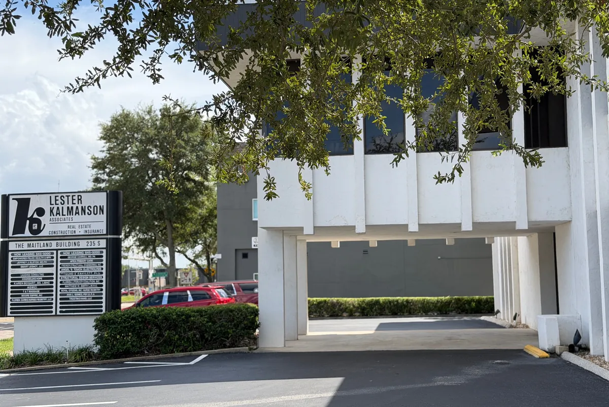 The covered entrance of the office building on Maitland Avenue, with the building's tenant sign on the left